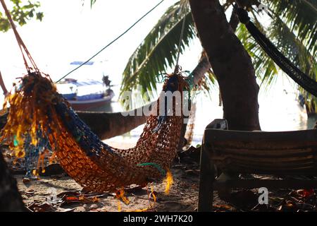 Hammock attached to palm tree on Sunset Beach in Koh Lipe, Thailand Stock Photo