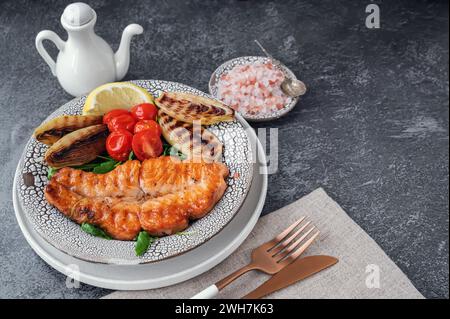 Grilled salmon steak with vegetables - cauliflower and broccoli, tomatoes and shallots. Healthy eating concept. Stock Photo