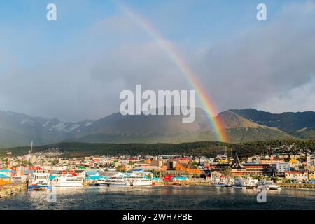 view of a rainbow over the city of Ushuaia with the Andes mountains in the background Stock Photo