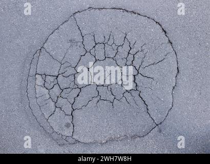 A large pit in the asphalt with cracks Stock Photo