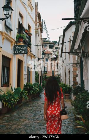 girl walking through the streets of Tossa de Mar in Catalonia, Spain, on July 4, 2019 Stock Photo