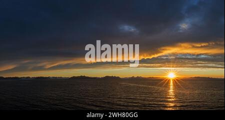 Sun setting on a rainy evening over Isfjorden / Isfjord in summer at sunset, Spitsbergen / Svalbard, Norway Stock Photo
