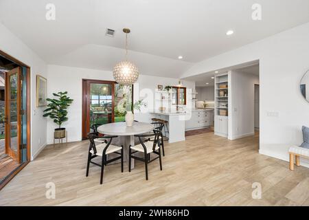 Dining area with furniture and table, bathed in natural light from surrounding windows Stock Photo