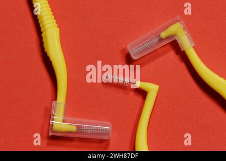 Image of yellow interdental toothpicks - brushes on a red background. Stock Photo