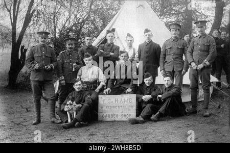 Aldershot, Hampshire. 1914 – British army soldiers of the Regimental Barber Shop, ‘F’ Company, Royal Army Medical Corps at Redan Hill Fort, Aldershot in 1914. The men are posing with their dog mascot in front of a bell tent. Some of the soldiers are wearing standard Khaki with Regimental Police armbands. The rest are wearing temporary blue serge uniforms, known as ‘Kitchener blues’. As a result of the War Office's failure to obtain a sufficient quantity of standard khaki uniforms in the opening weeks of the First World War, this alternative was introduced as an emergency measure. Stock Photo