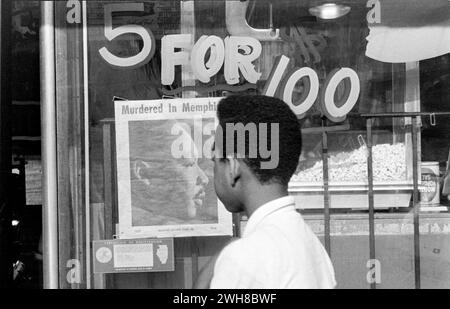 Young Man Contemplating Dr. King Murdered in Memphis Newspaper  in a Store Window Stock Photo