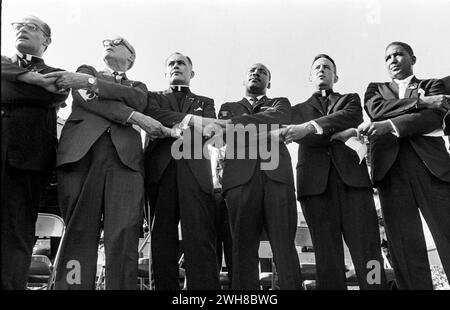 United Front: Dr. Martin Luthur King with Diverse Group of Men Joining Hands in Solidarity at Daytime Event Stock Photo