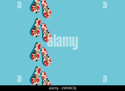 Creative sunlight summer composition made with floral slippers on bright blue background with copy space. Minimal summer concept. Stock Photo