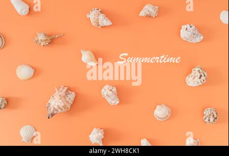 Trendy summer pattern made of sea shells on pastel peachy orange background. Nature summertime concept. Minimal sea shells pattern composition. Stock Photo