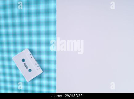 Layout of retro white audio cassette tape on white and blue background. Creative concept of old technology. 80's aesthetic. Vintage audio cassette Stock Photo