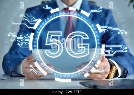 Businessman using digital tablet and 5G network internet mobile wireless interface icon. Global business and information technology concept. Stock Photo