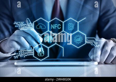 Businessman hands using tablet computer and virtual hexagons hologram with digital business icons. Virtual reality and global networking concept. Stock Photo