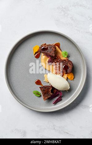 Spiced banana pudding, Valrhona Dulcey crémeux, salted caramel, vanilla bean ice cream, dark rum syrup Stock Photo