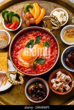 Fried egg with tomatoes in copper pan and various snacks for Breakfast on copper tray Stock Photo