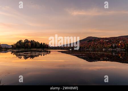 Colorful autumn evening reflecting in lake. Colourful autumn sunset in mountain lake. Colorful autumn landscape. Parc national Mont Tremblant. Quebec. Stock Photo