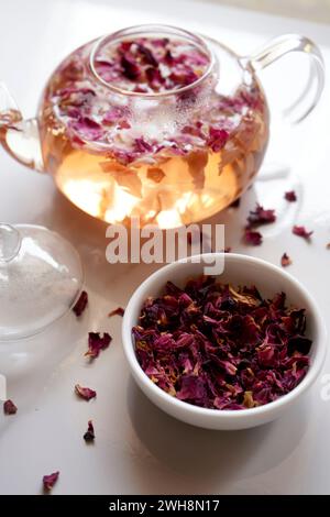 Rose petal herbal tea with dried flowers and teapot closeup. Stock Photo