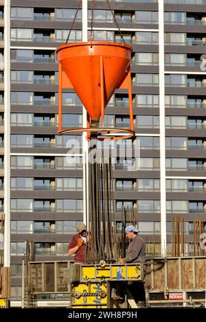 Construction building workers pouring concrete mix in reinforcement form at construction site in Sofia Bulgaria, Eastern Europe, Balkans, EU Stock Photo