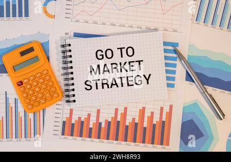 Business concept. On business reports there is a calculator and a sign with the inscription - Go to market strategy. Stock Photo