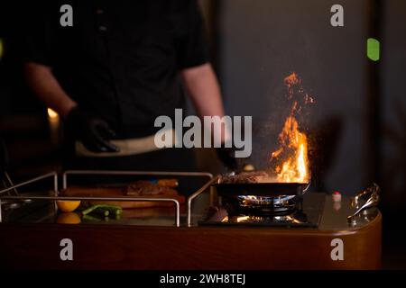 Close-up shot, a professional chef expertly prepares a delicious steak using modern cooking techniques, showcasing culinary excellence and precision Stock Photo