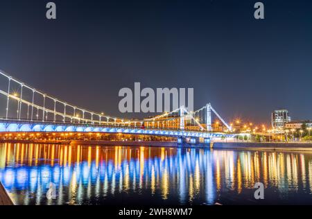 Krymsky Bridge or Crimean Bridge in Moscow at summer night. Steel suspension bridge in Moscow over the Moskva River Stock Photo