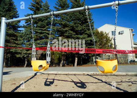 Closed off swing set in a park during Covid 19 pandemic, province of Quebec, Canada. Stock Photo