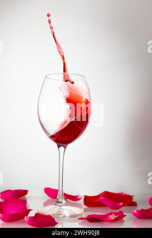 Glass of red wine with splashes on white. Stock Photo