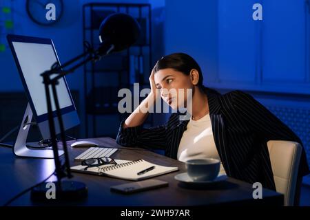 Tired businesswoman working at night in office Stock Photo