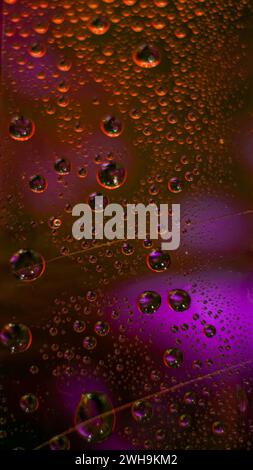 Abstract orange and purple cyberpunk colored drops of water on tape Stock Photo
