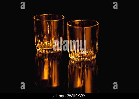 Black and orange isolated empty Whiskey drinking crystal glasses with reflections Stock Photo