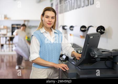 Technician operator calibrating plotter machine, typing on computer keyboard Stock Photo