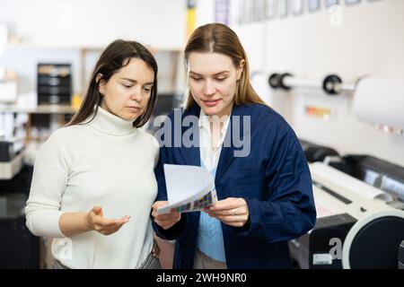 Women publishing facility workers having conversation about work Stock Photo