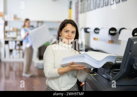 Technician working on plotter and cutter machine in printing shop Stock Photo