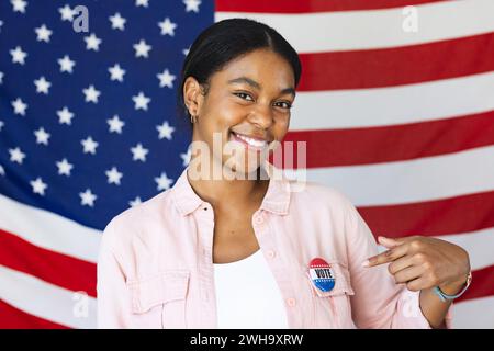 Biracial woman promotes civic engagement with her 'I Voted' sticker. Stock Photo