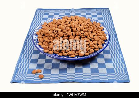 Bowl of kruidnoten on blue kitchen towel Stock Photo