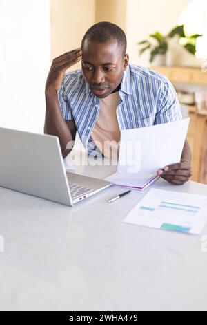 Young African American man reviews documents at home office Stock Photo