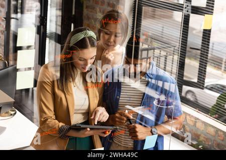 Young Caucasian woman collaborates with an Asian couple in a casual business setting in an office Stock Photo