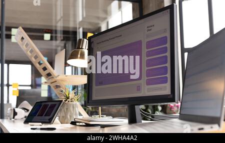 A modern casual business office setup features a computer monitor displaying a user interface Stock Photo