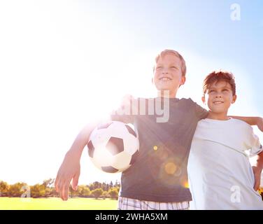 Soccer, friends and hug for unity on field, support and solidarity for sports game on grass. Happy boys, children and embrace on outdoor pitch Stock Photo