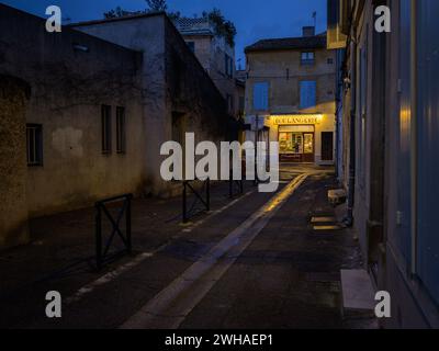 Arles, France - March 7, 2023: Empty street in the center of Arles (France) in the night, bakery Stock Photo