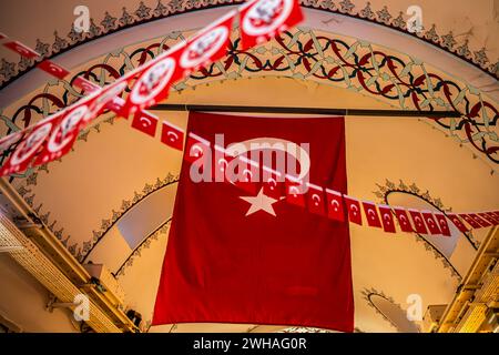 The Turkish flag proudly displayed at the top of the Grand Bazaar, creating a patriotic and vibrant symbol of national pride inside this historical an Stock Photo