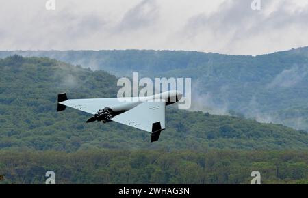 Military kamikaze drone flying over forest in the clouds, Combat drone in the sky, war in Ukraine. Iranian drone attack Shahed. Stock Photo