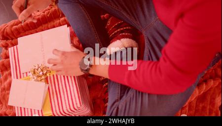 Person wrapping Christmas gifts at home, with copy space Stock Photo