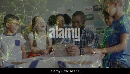 Image of networks over happy african america male teacher and pupils using tablet in class Stock Photo