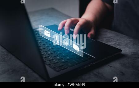 Contact us or Customer support hotline people connect. Businesswoman using laptop with hologram icons. Feedback, business and finance concept. Stock Photo