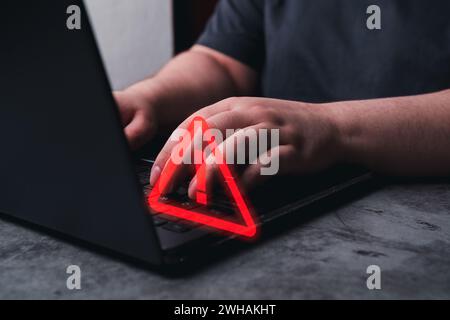 Woman use laptop with hologram warning sign for notification error. Programmer, developer and maintenance system concept. Scam virus attack. Security Stock Photo