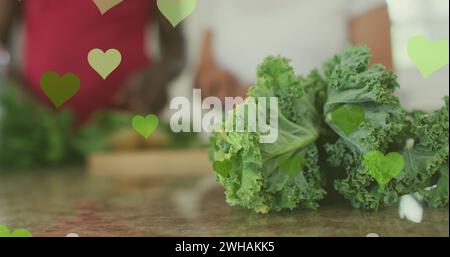Image of hearts over senior african american couple cooking Stock Photo