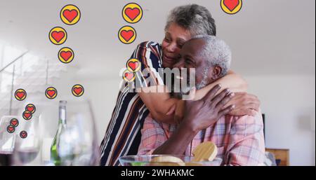 Image of hearts over senior african american couple embracing Stock Photo