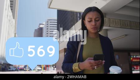 Image of like thumbs up icon with numbers changing over woman using smartphone in city Stock Photo