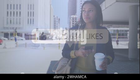 Image of like thumbs up icon with numbers changing over woman using smartphone in city Stock Photo