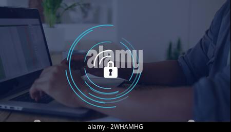 Image of padlock icon over caucasian businessman using laptop in office Stock Photo